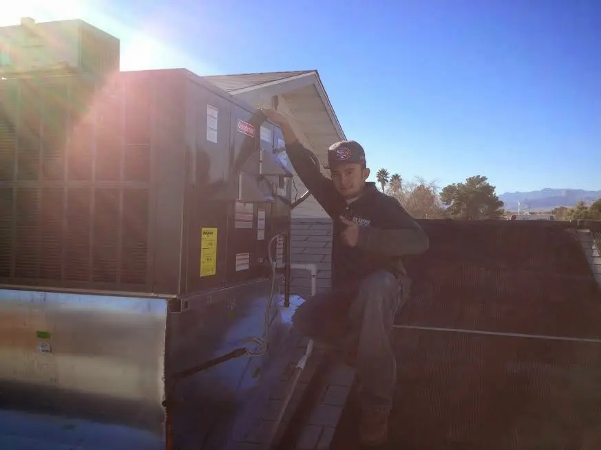 HVAC technician performing AC Tune-Up on a rooftop unit in Carteret